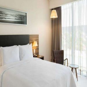 Bright queen room with window at the Hampton Inn by Hilton Cancun Cumbres.