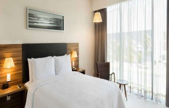 Bright queen room with window at the Hampton Inn by Hilton Cancun Cumbres.