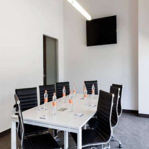 Small meeting room with TV screen at the Hampton Inn by Hilton Cancun Cumbres.