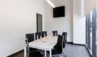 Small meeting room with TV screen at the Hampton Inn by Hilton Cancun Cumbres.