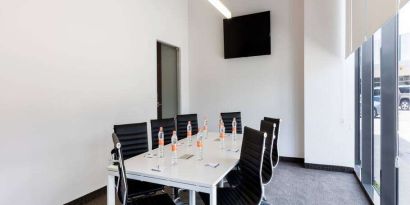 Small meeting room with TV screen at the Hampton Inn by Hilton Cancun Cumbres.