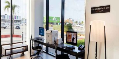 Working station with computers and printer at the Hampton Inn by Hilton Cancun Cumbres.