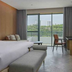 spacious king bedroom with desk, chair, and lounge suite at Hilton Guangzhou Science City.