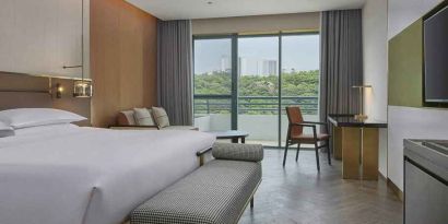 spacious king bedroom with desk, chair, and lounge suite at Hilton Guangzhou Science City.