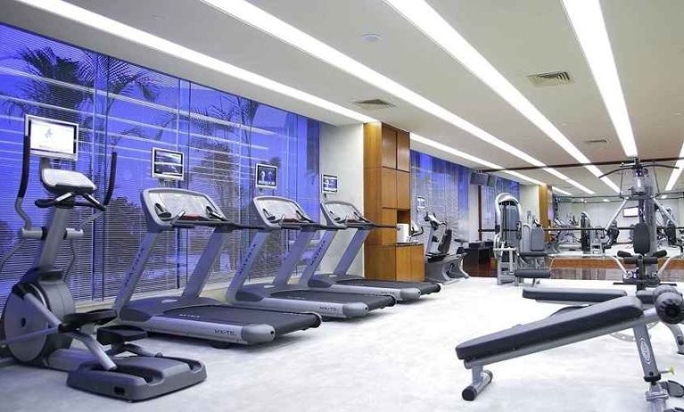 well equipped fitness center with treadmills, bikes, and weights at Hilton Guangzhou Science City.