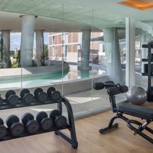 Fitness center with weights and machines at the Hilton Garden Inn Cancun Airport.