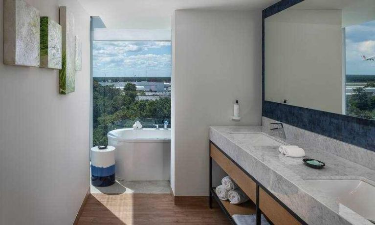 Bathroom with bath tub overlooking the airport at the Hilton Garden Inn Cancun Airport.