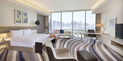 King suite with desk, sofa and TV screen at the DoubleTree by Hilton Doha - Old Town.