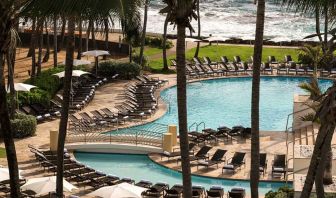 Relaxing outdoor pool area with lounges at the Caribe Hilton.