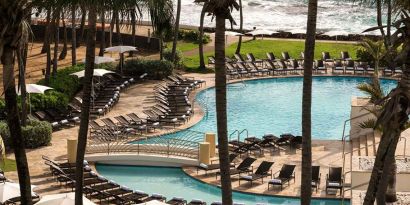 Relaxing outdoor pool area with lounges at the Caribe Hilton.