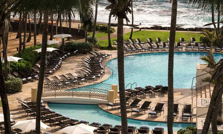 Relaxing outdoor pool area with lounges at the Caribe Hilton.