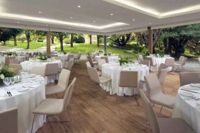 Dining area set in a beautful garden at the Boeira Garden Hotel Porto Gaia, Curio Collection by Hilton.