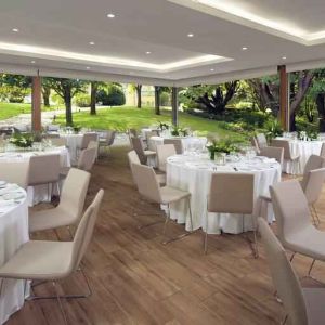 Dining area set in a beautful garden at the Boeira Garden Hotel Porto Gaia, Curio Collection by Hilton.