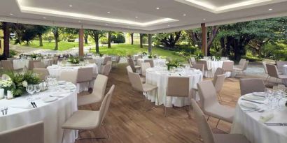 Dining area set in a beautful garden at the Boeira Garden Hotel Porto Gaia, Curio Collection by Hilton.