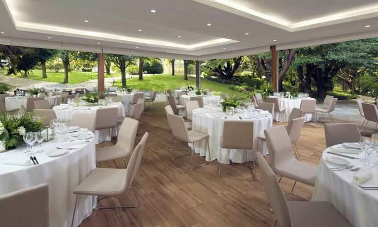 Dining area set in a beautful garden at the Boeira Garden Hotel Porto Gaia, Curio Collection by Hilton.