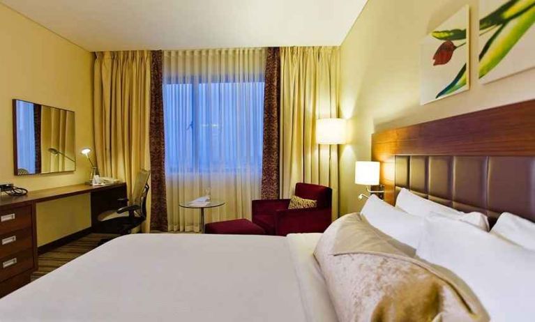 comfortable delux king room with TV, desk, chair, and couch at Hilton Garden Inn Kutahya.