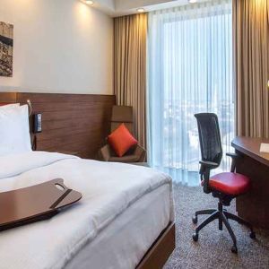 spacious king bedroom with TV, desk, chair, and couch at Hampton by Hilton Samsun.