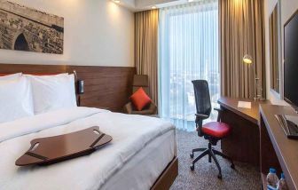 spacious king bedroom with TV, desk, chair, and couch at Hampton by Hilton Samsun.