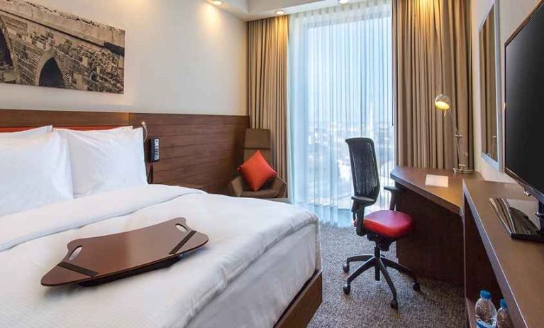 spacious king bedroom with TV, desk, chair, and couch at Hampton by Hilton Samsun.