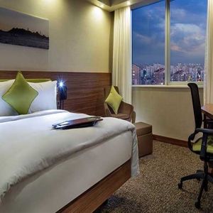 comfortable king bedroom with TV, desk, and chair at Hampton by Hilton Istanbul Kayasehir.