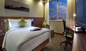 comfortable king bedroom with TV, desk, and chair at Hampton by Hilton Istanbul Kayasehir.