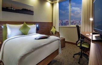 comfortable king bedroom with TV, desk, and chair at Hampton by Hilton Istanbul Kayasehir.