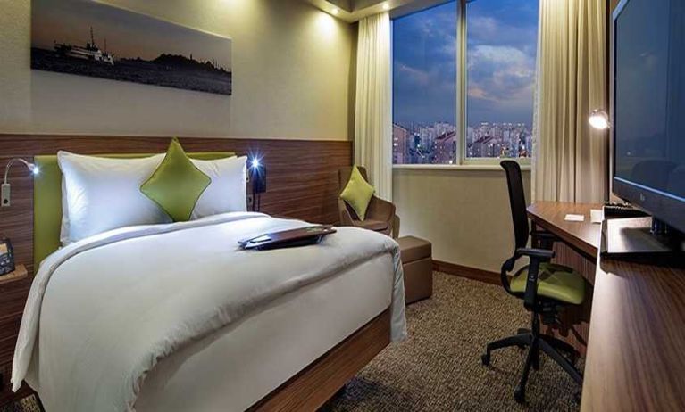 comfortable king bedroom with TV, desk, and chair at Hampton by Hilton Istanbul Kayasehir.