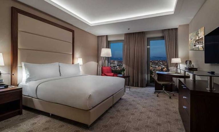 comfortable king bedroom with TV, desk, and chair at DoubleTree by Hilton Istanbul Topkapi.