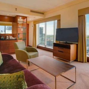 Spacious living room with view, working station and sofa at the Hilton Warsaw City.