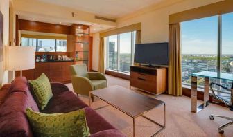 Spacious living room with view, working station and sofa at the Hilton Warsaw City.