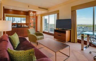 Spacious living room with view, working station and sofa at the Hilton Warsaw City.