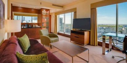 Spacious living room with view, working station and sofa at the Hilton Warsaw City.