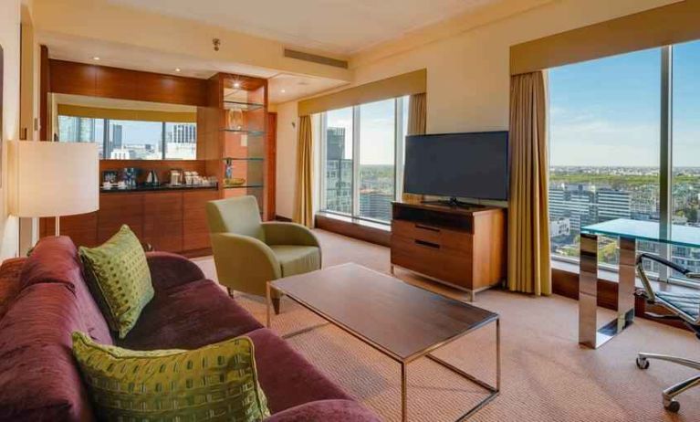 Spacious living room with view, working station and sofa at the Hilton Warsaw City.