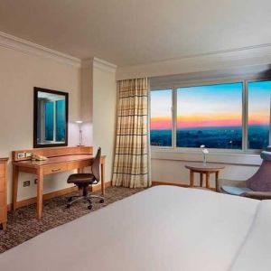 lovely king bedroom with TV, desk, and chair at Adana HiltonSA.