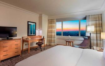 lovely king bedroom with TV, desk, and chair at Adana HiltonSA.