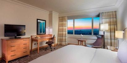 lovely king bedroom with TV, desk, and chair at Adana HiltonSA.