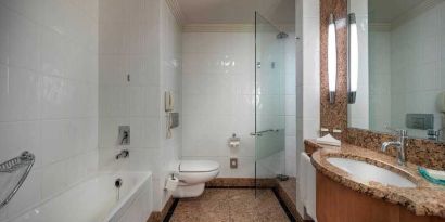 spacious bathroom with bath and shower at Adana HiltonSA.