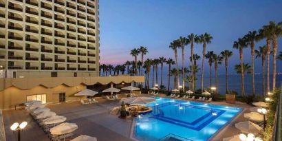 stunning outdoor pool with sun beds and seating area at Mersin HiltonSA.