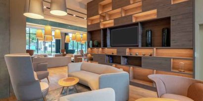 Hotel workspace with sofas and TV screen at the Hampton by Hilton Warsaw Mokotow.