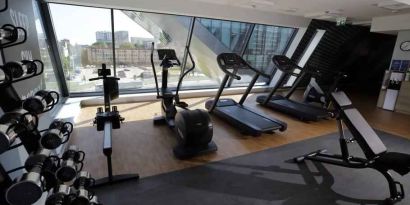 Fitness center with weights and machines at the Hampton by Hilton Olsztyn.