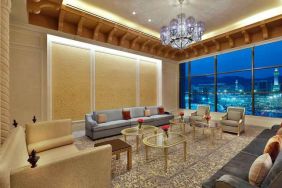 Seating area with large window and view at the Hilton Makkah Convention Hotel.