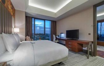 spacious king room with TV, work desk, chair, and couch at Hilton Garden Inn Istanbul Ataturk Airport.