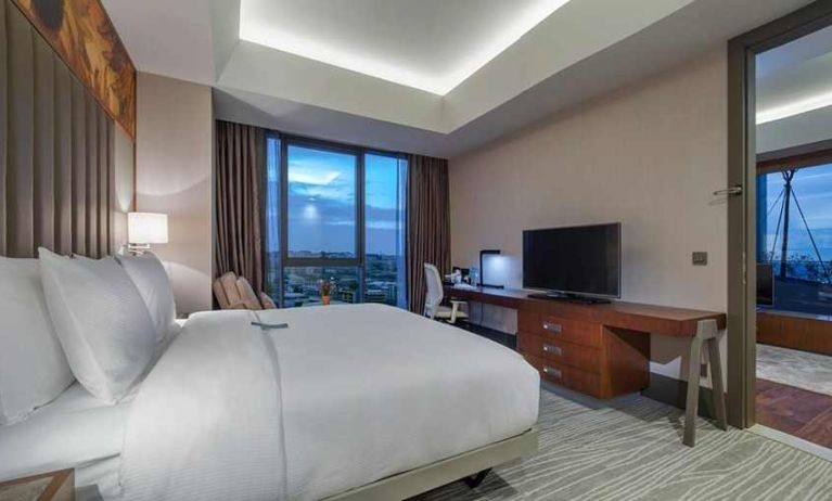 spacious king room with TV, work desk, chair, and couch at Hilton Garden Inn Istanbul Ataturk Airport.