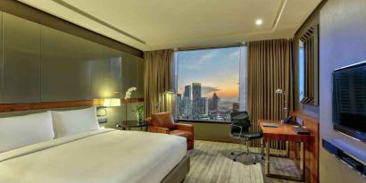 King bedroom with desk along the window at the Hilton Sukhumvit Bangkok.