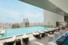 Beautiful outdoor pool with lounges overlooking the city at the Hilton Sukhumvit Bangkok.