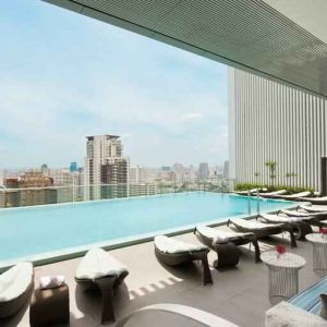 Beautiful outdoor pool with lounges overlooking the city at the Hilton Sukhumvit Bangkok.