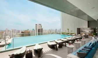 Beautiful outdoor pool with lounges overlooking the city at the Hilton Sukhumvit Bangkok.