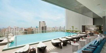 Beautiful outdoor pool with lounges overlooking the city at the Hilton Sukhumvit Bangkok.