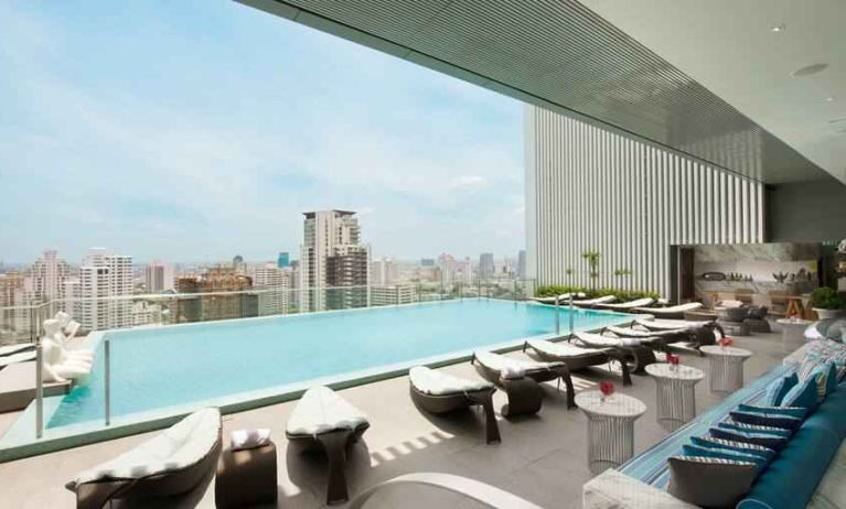 Beautiful outdoor pool with lounges overlooking the city at the Hilton Sukhumvit Bangkok.