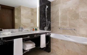 clean and spacious king bathroom with bath and shower at Hilton Astana.